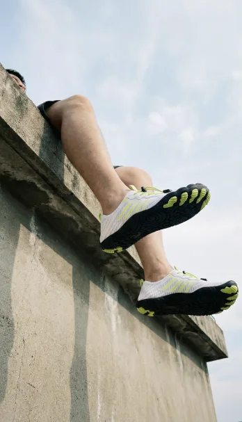 Person wearing lightweight Grounded Footwear barefoot shoes while jumping from an outdoor wall